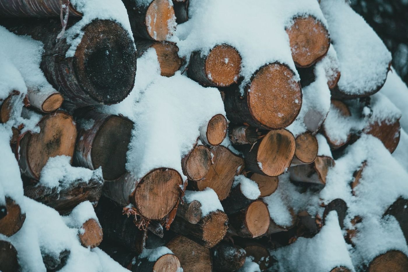 Sniegu apsnigta malkų rietuvė žiemą – tradicinis šildymas malkomis