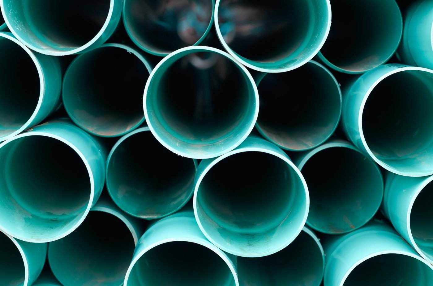 Krūva sukrautų plastikinių vamzdžių, sudėtų vienas ant kito