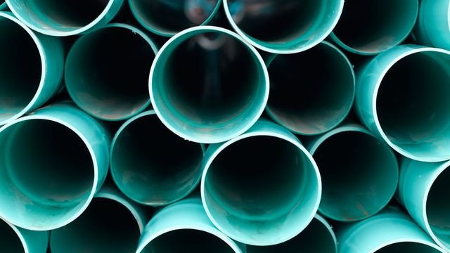 Krūva sukrautų plastikinių vamzdžių, sudėtų vienas ant kito